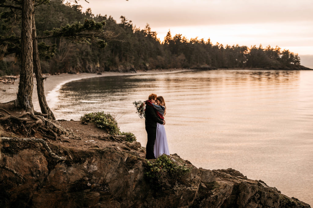 A bride and groom share an emotional hug on a cliff side for their Washington State Elopement.