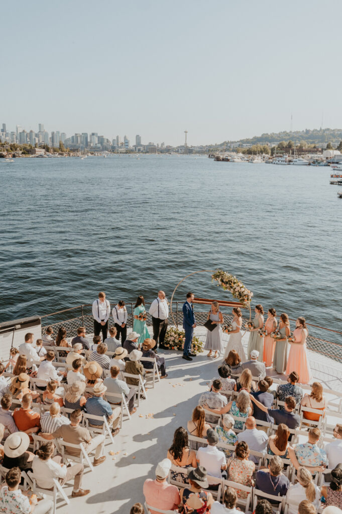 A wedding ceremony taking place on the MV Skansonia, a wedding venue overlooking Lake Union and the Seattle skyline