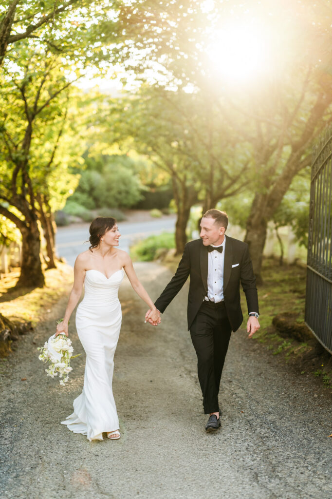 Bride and groom walk hand in hand for their golden hour portraits at Chateau Lill.
