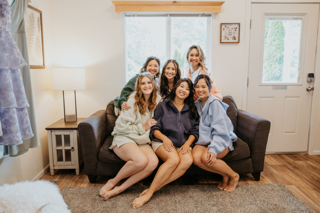 A bride and her bridesmaids sit together for a photo before a wedding at Twin Willow Gardens.